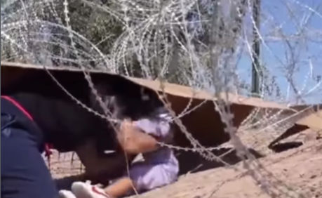 Vídeo mostra mãe e criança atravessando fronteira por baixo de cerca